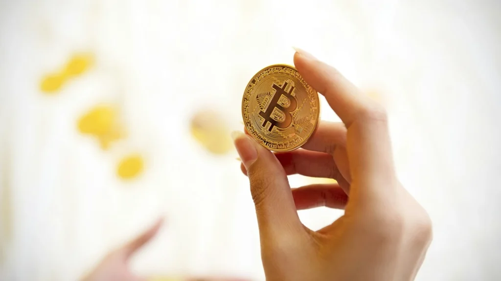 手に持ったビットコインのイメージ